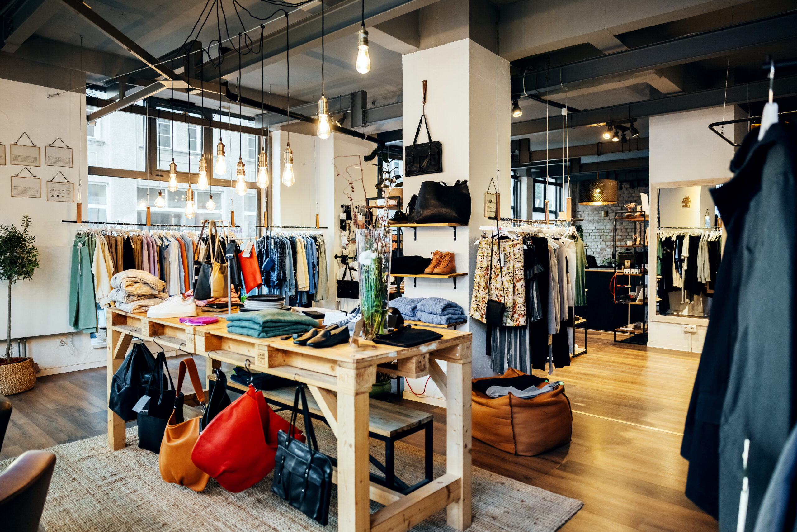 The retail displays and items of clothing on display in a fashionable high street clothing store, with no people.